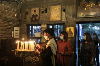 Κόσμος σε εκκλησία ανάβει κεριά