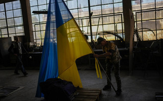 volunteer places a Ukraine flag on a metal bar at a facility producing material for Ukrainian soldiers in Zaporizhzhia, Ukraine, Friday, May 6, 2022 volunteer places a Ukraine flag on a metal bar at a facility producing material for Ukrainian soldiers in Zaporizhzhia, Ukraine, Friday, May 6, 2022