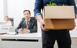 An employee resigns and leaves work with a box in his hands