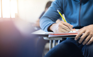 Student sits at a desk and writes