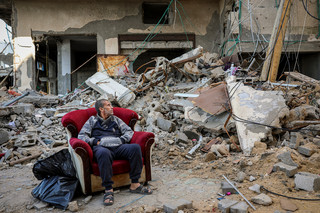 Παλαιστίνιος μπροστά σε κατεστραμμένο κτήριο στη Γάζα