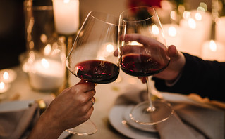 Άντρας και γυναίκα τσουγκρίζουν ποτήρια με κρασί