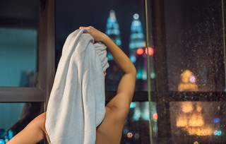 Γυναίκα στεγνώνει τα μαλλιά της με πετσέτα