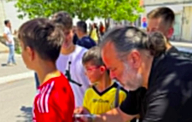 Ηλιόπουλος υπογράφει φανέλα Ολυμπιακού με μήνυμα σε μικρό φίλαθλο από την ΑΕΚ