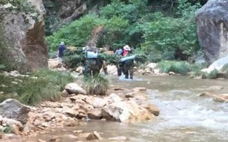 Αστυνομικοί μεταφέρουν κατασχεμένο χασίς μέσα από το ποτάμι