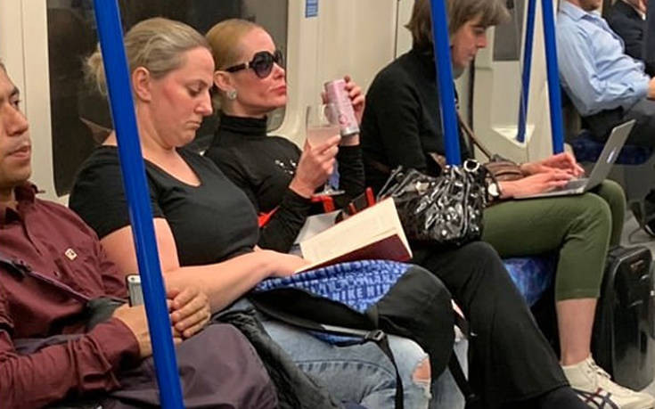 Γυναίκα πίνει το ποτό της σε βαγόνι του μετρό