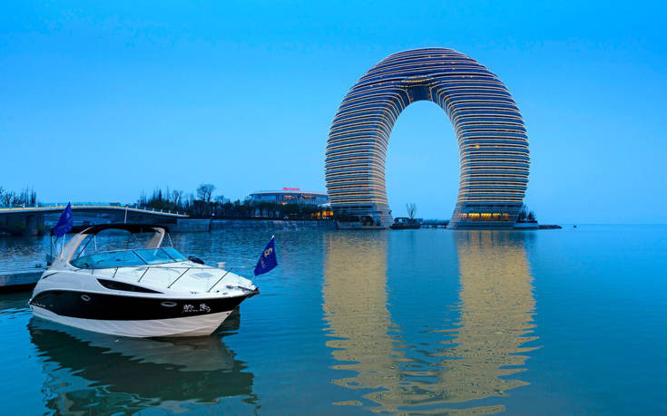 Ένα φουτουριστικό ξενοδοχείο σε σχήμα πετάλου αναδύεται από λίμνη στην Κίνα