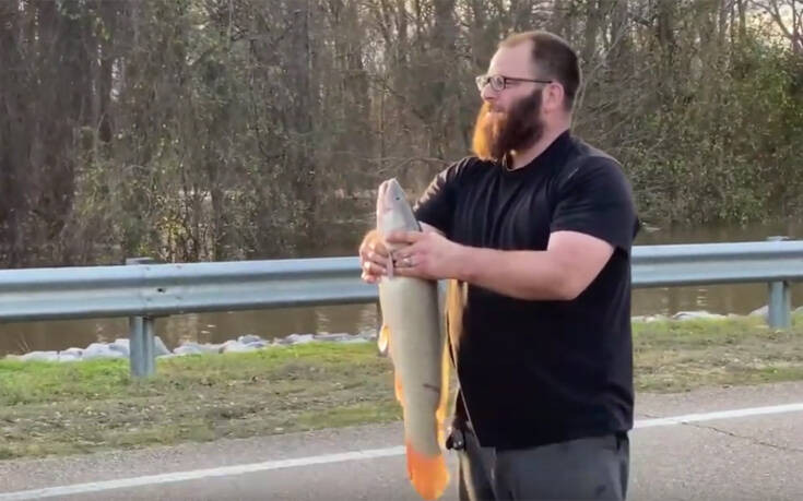 Τυχερός άνδρας έβγαλε ψάρι από πλημμυρισμένο δρόμο