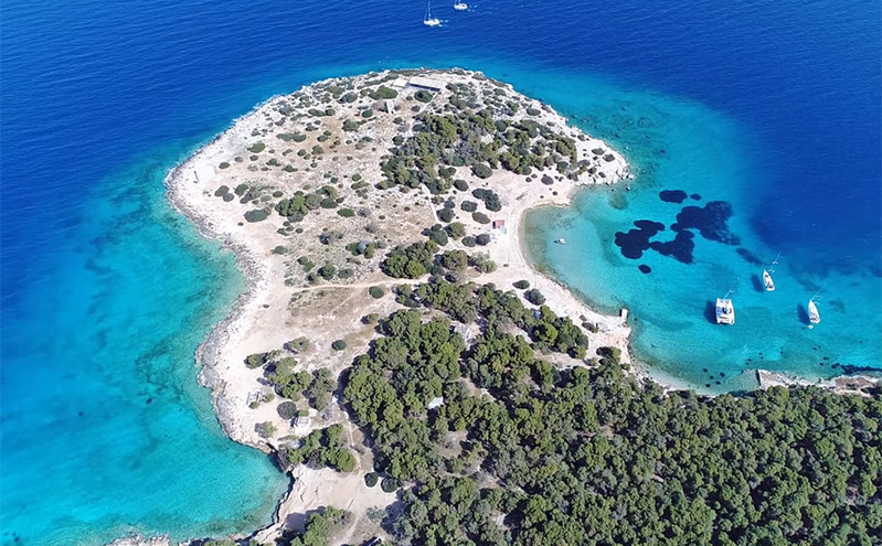 To νησάκι στον Σαρωνικό που μοιάζει με τιρκουάζ μανιτάρι και στις ξαπλώστρες κάθονται παγώνια