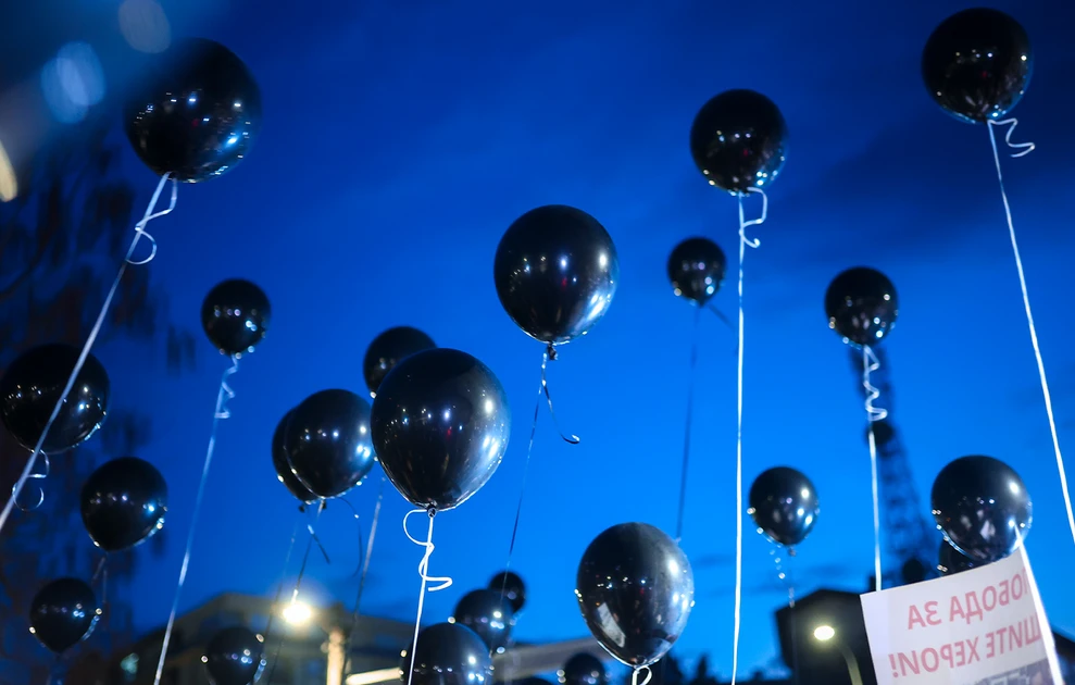 a group of black balloons in the sky