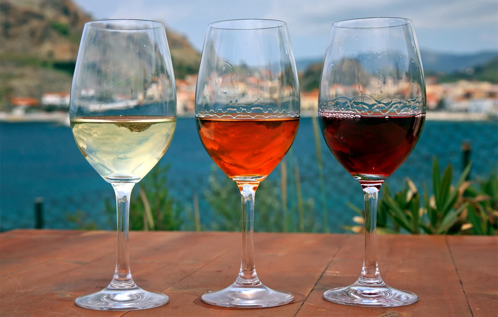 a group of wine glasses with different colored wine in them